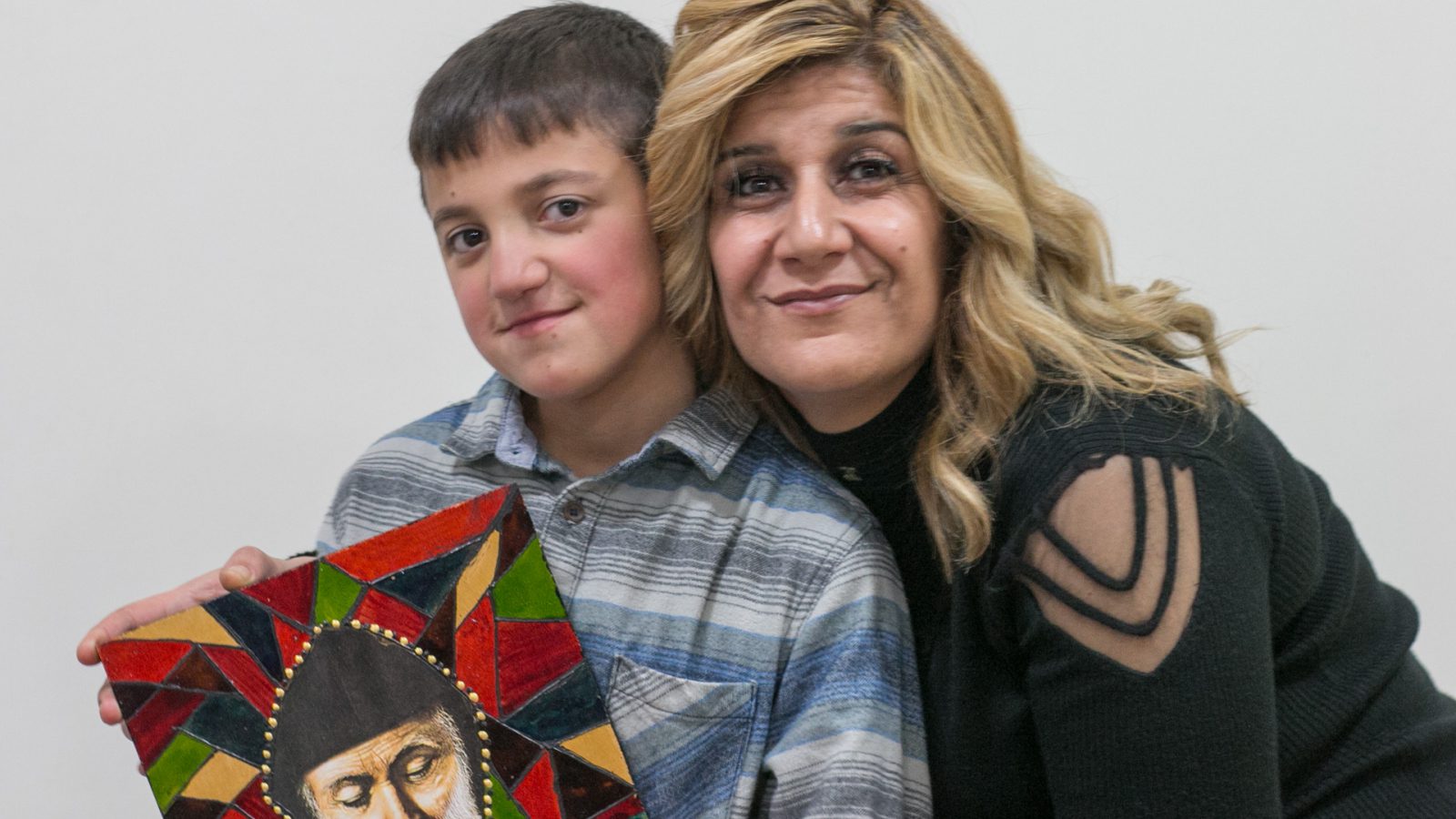 Faten Merhi and his son Loubnan pose with a painting by Mar Charbel that Faten made during the pottery and decoration workshop given by the NGO La Voix de la Femme and funded by the EU as part of the DAWRIC project. Chiyah, Lebanon